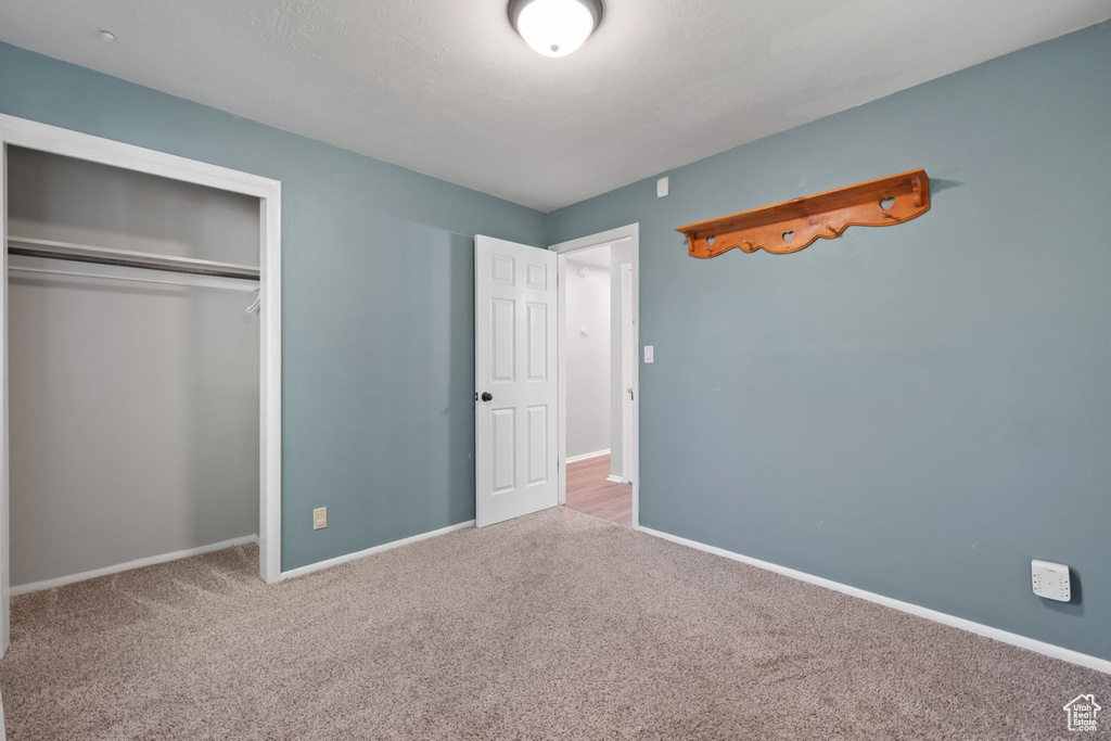 Unfurnished bedroom featuring carpet and a closet