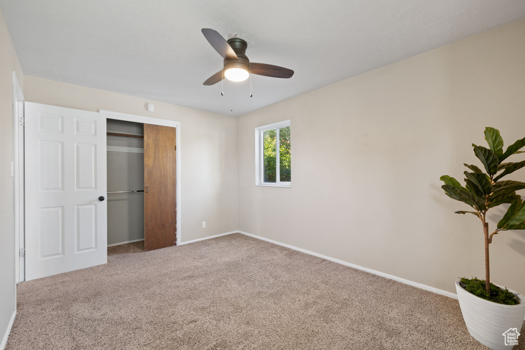 Unfurnished bedroom with carpet floors, a closet, and ceiling fan