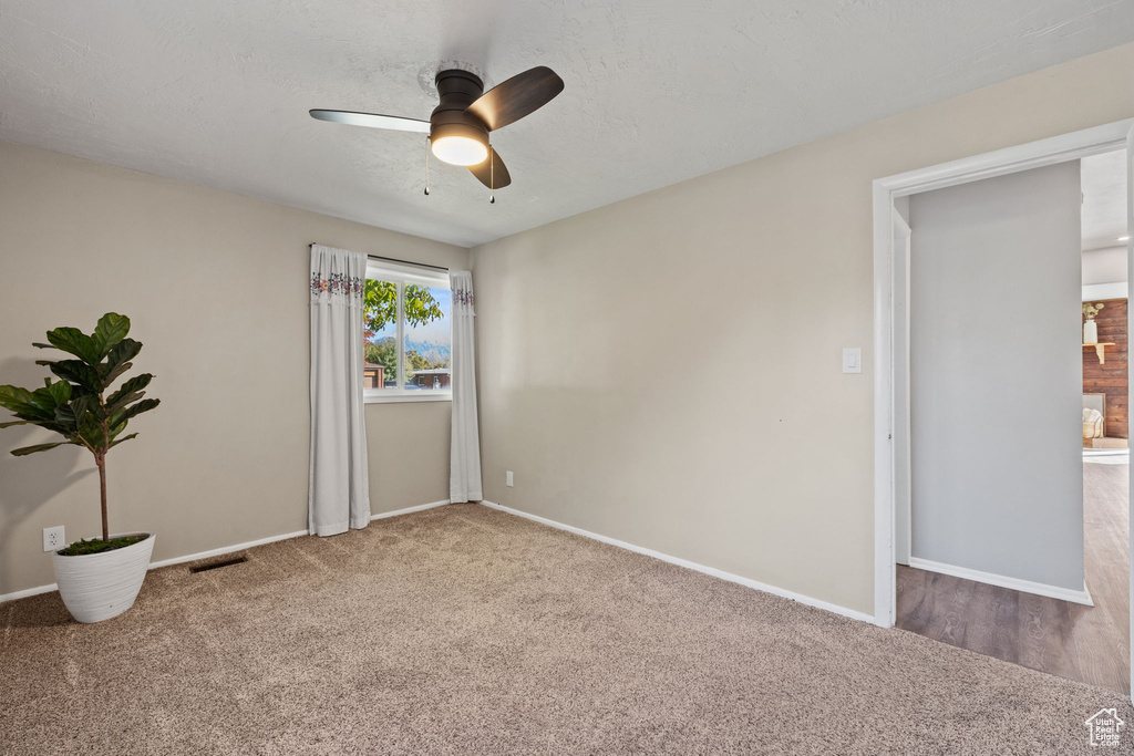 Carpeted empty room with ceiling fan