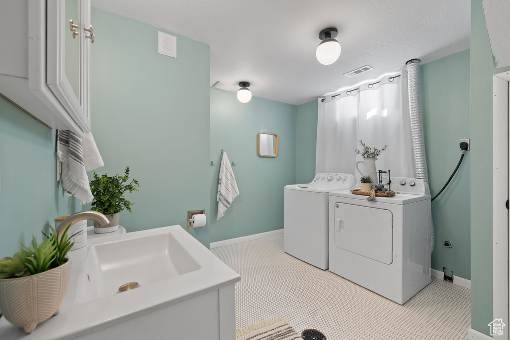 Clothes washing area with light carpet, washer and dryer, and sink