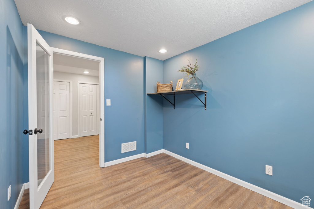 Spare room featuring a textured ceiling and hardwood / wood-style flooring