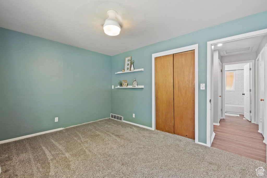 Unfurnished bedroom with carpet flooring and a closet