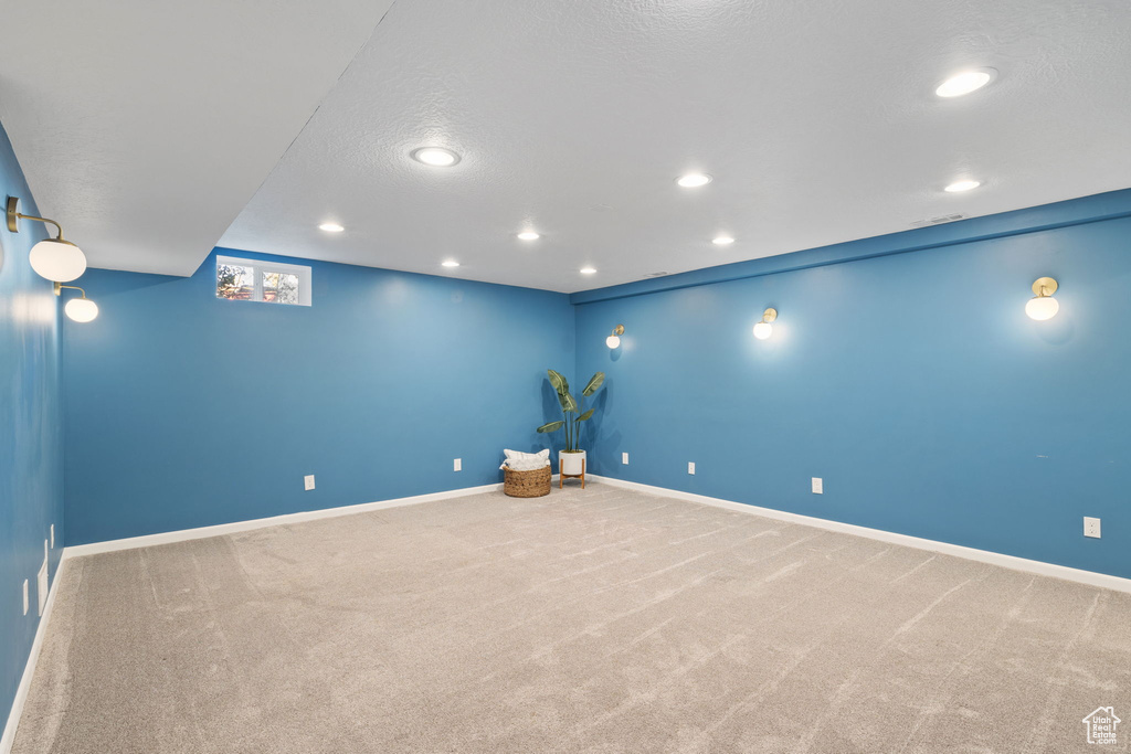 Carpeted home theater featuring a textured ceiling