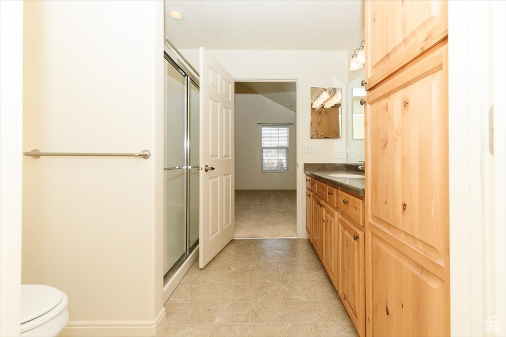 Full bath featuring vanity, a shower stall, toilet, and tile patterned floors