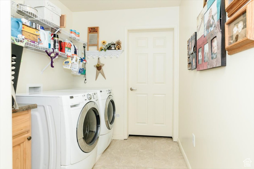 Laundry area featuring washing machine and dryer and light tile patterned flooring