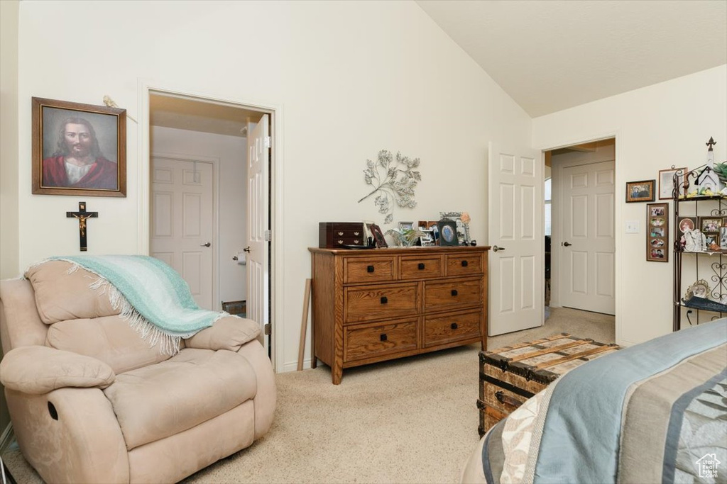 Bedroom featuring light colored carpet and high vaulted ceiling