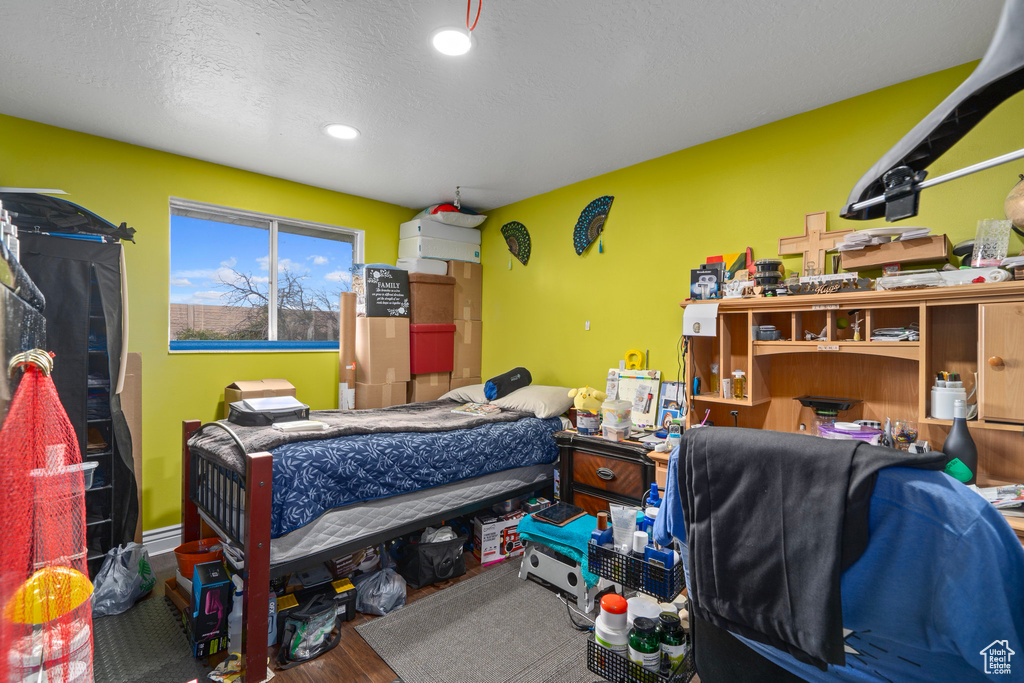 Bedroom with a textured ceiling and wood-type flooring