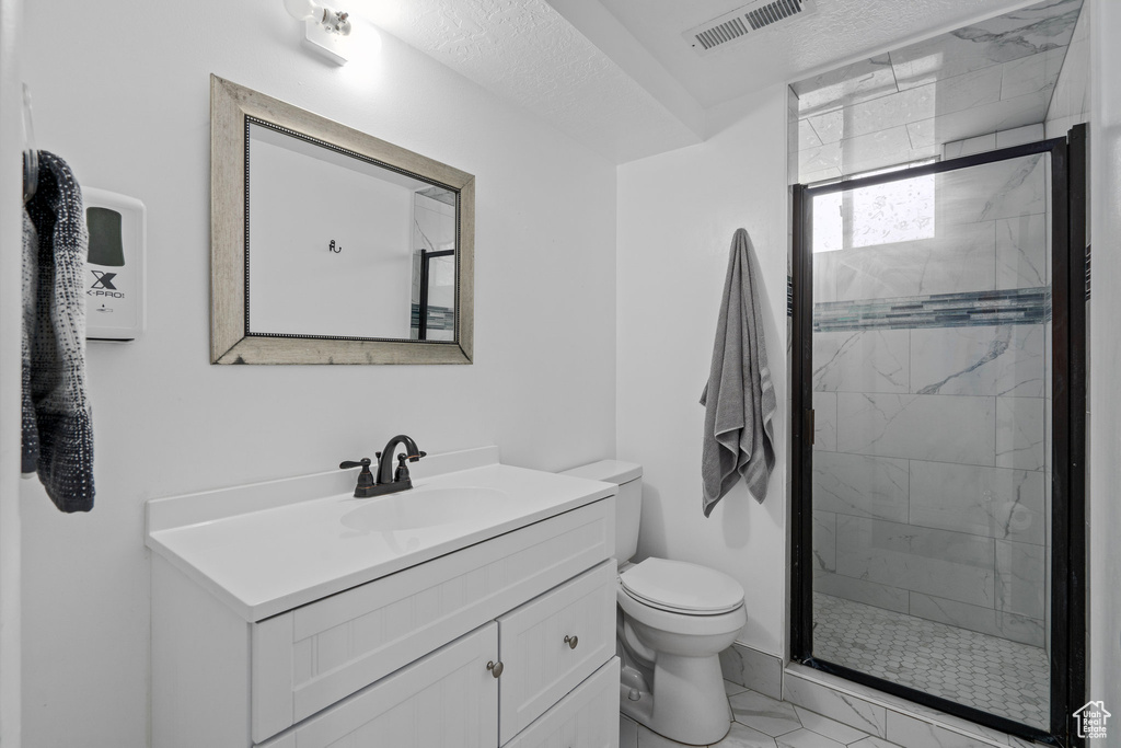 Bathroom with vanity, toilet, and an enclosed shower