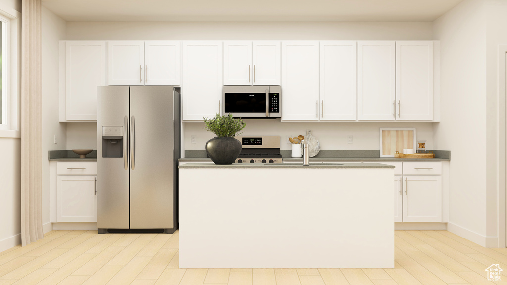 Kitchen featuring stainless steel appliances, a center island with sink, and white cabinets