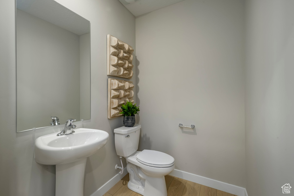 Bathroom featuring toilet, wood-type flooring, and sink