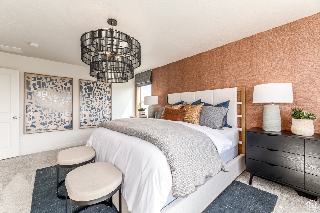 Bedroom with an inviting chandelier and carpet floors