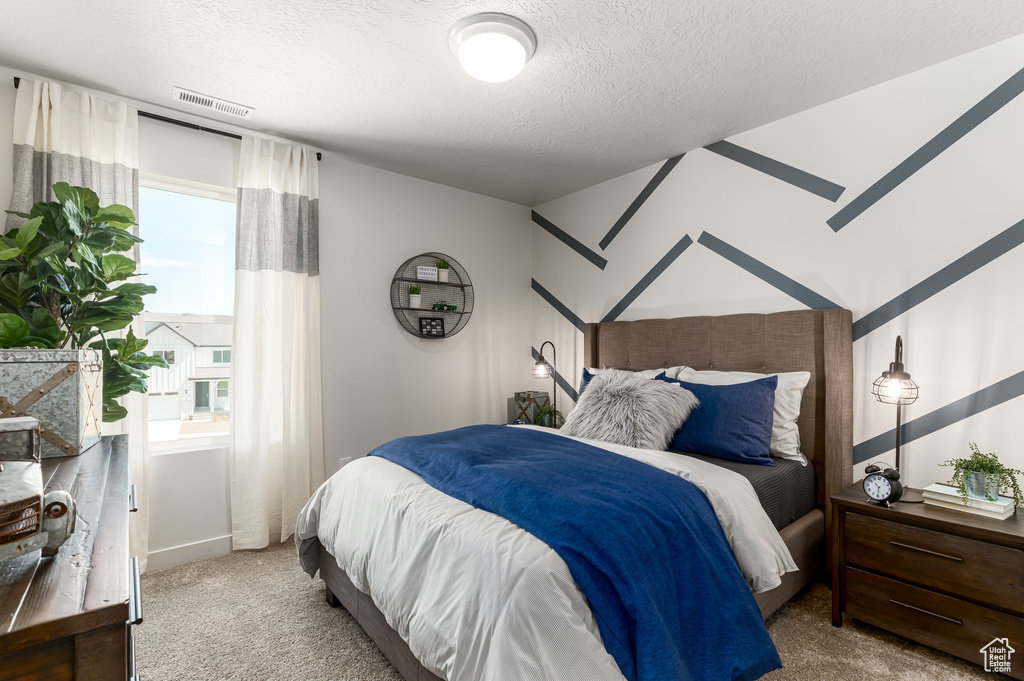 Bedroom featuring light carpet, a textured ceiling, and vaulted ceiling