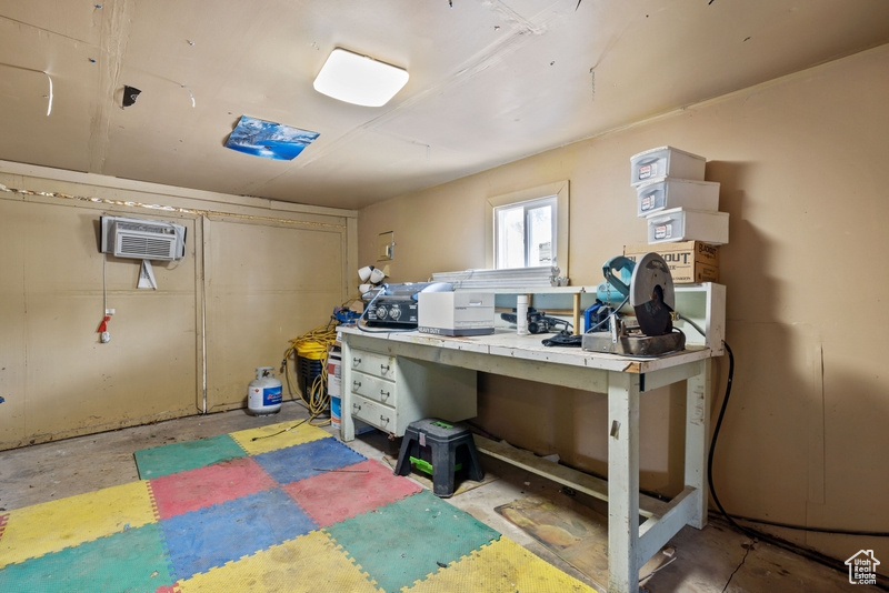 Basement featuring a wall mounted AC and a workshop area