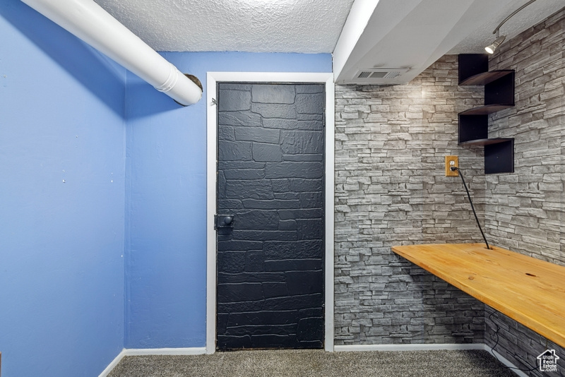 Interior space featuring a textured ceiling, butcher block counters, and carpet floors