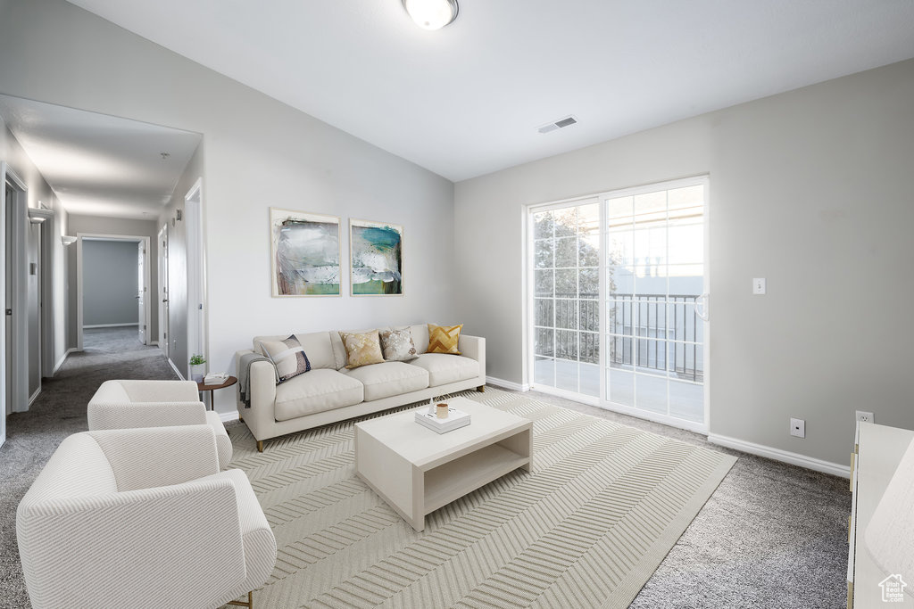 Carpeted living room with lofted ceiling