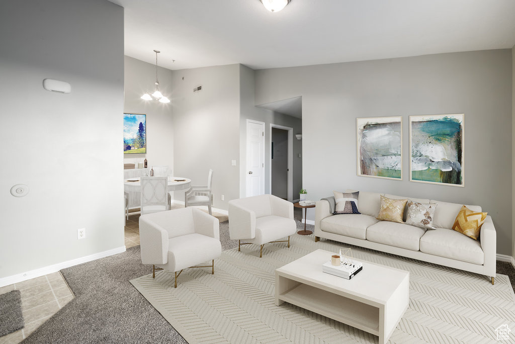 Living room with light carpet, an inviting chandelier, and high vaulted ceiling