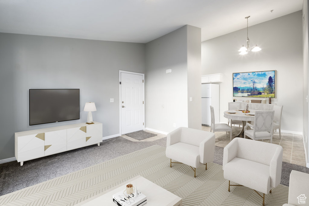 Living room with a notable chandelier, carpet floors, and high vaulted ceiling