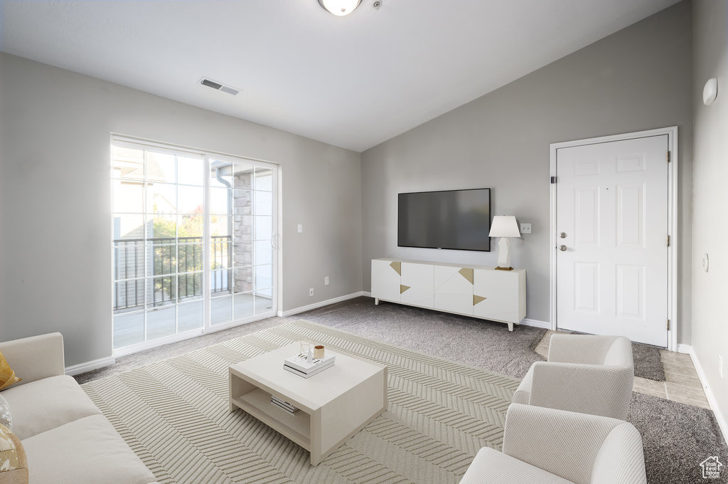 Living room with light colored carpet and high vaulted ceiling