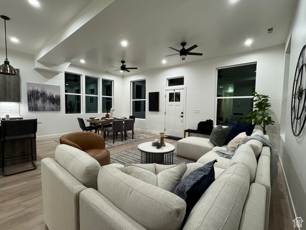 Living room with ceiling fan and light wood-type flooring