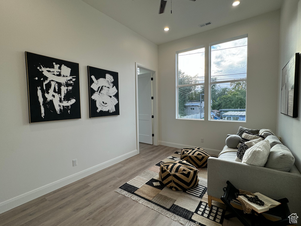 Living area with light hardwood / wood-style flooring and ceiling fan