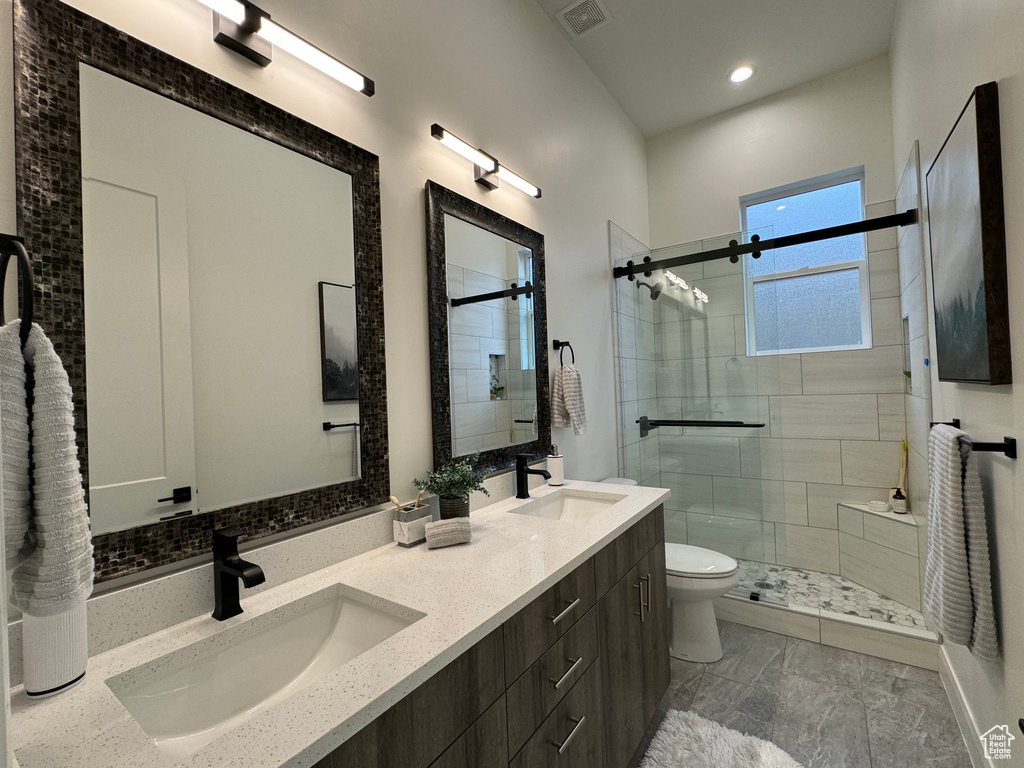 Bathroom with vanity, toilet, and a shower with shower door