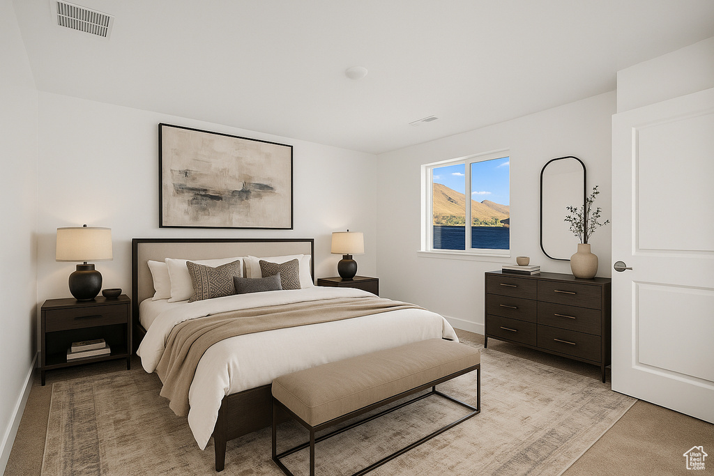 Bedroom with baseboards, light colored carpet, and visible vents