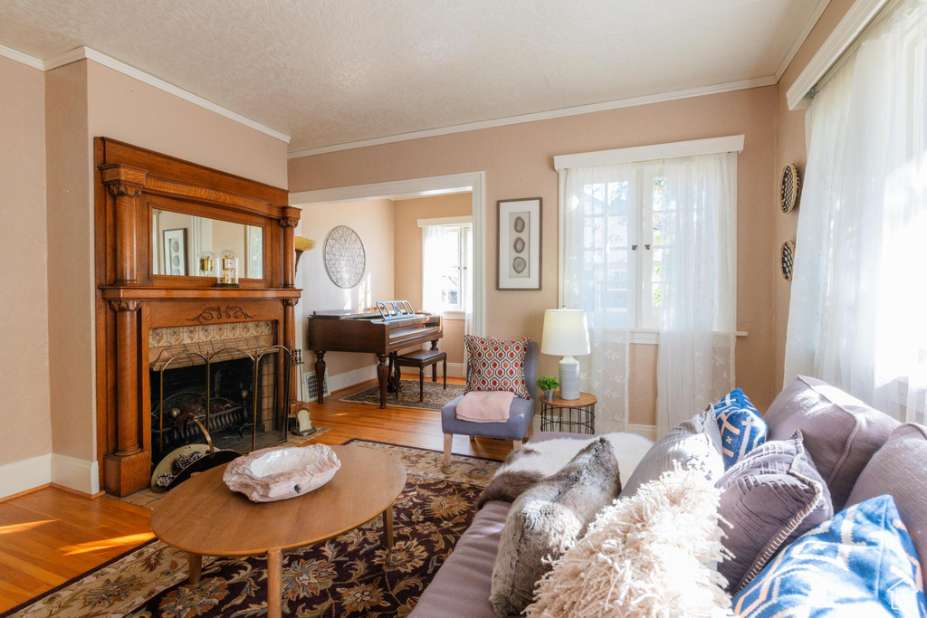 Living room featuring crown molding, hardwood / wood-style floors, and a textured ceiling