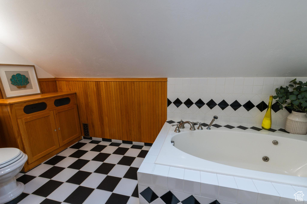 Bathroom featuring toilet and tiled bath