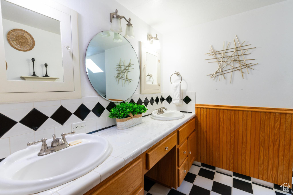 Bathroom with vanity and tasteful backsplash