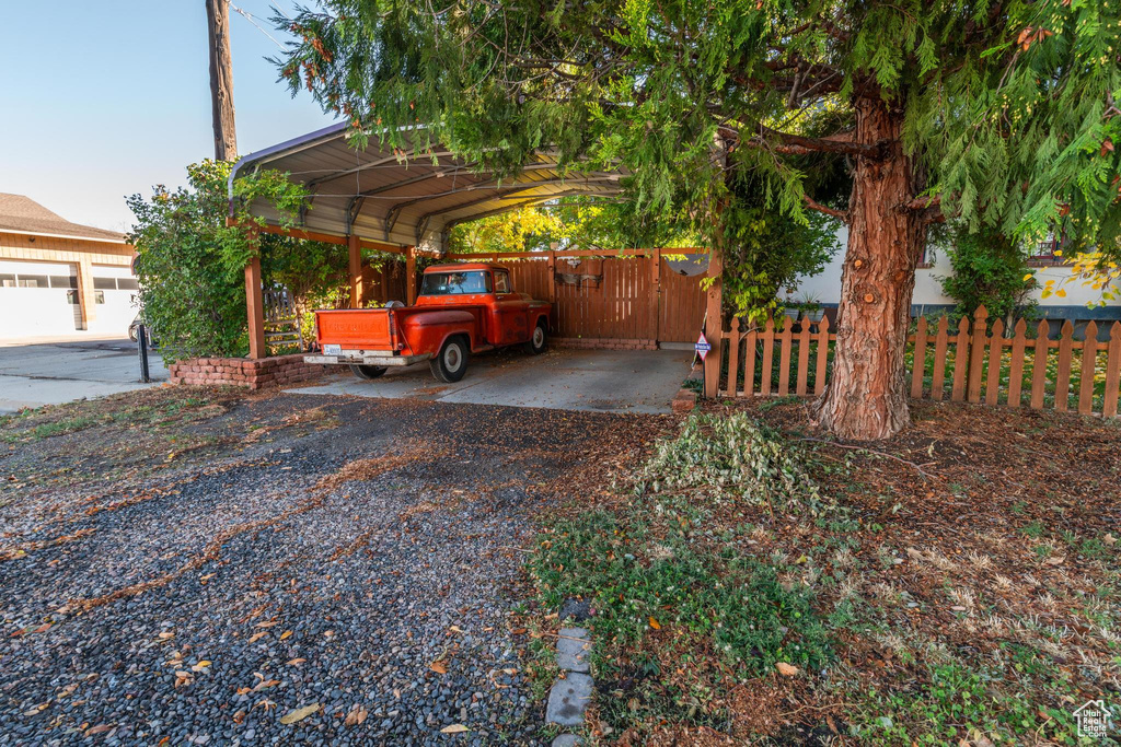 View of vehicle parking featuring a garage and a carport