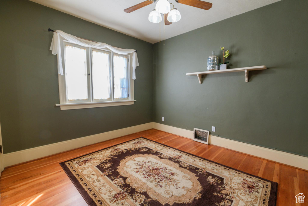 Empty room featuring ceiling fan and hardwood / wood-style floors