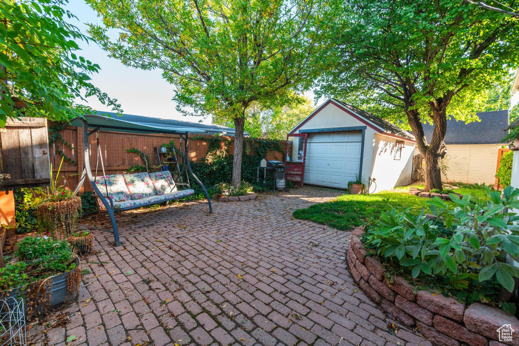 View of patio / terrace with an outdoor structure, a garage, and grilling area