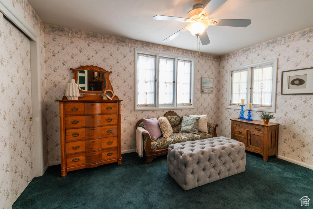 Sitting room featuring dark carpet and ceiling fan