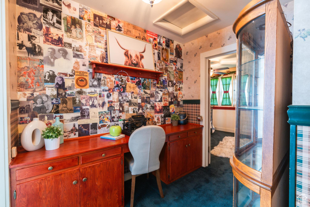 Carpeted office featuring built in desk and ceiling fan