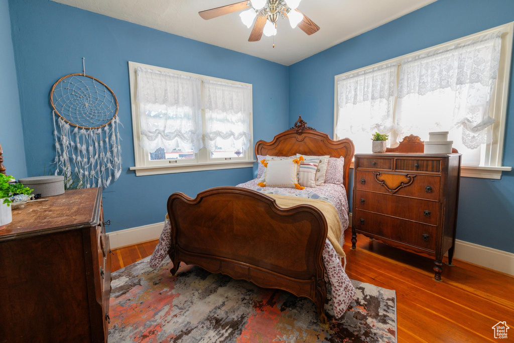 Bedroom featuring hardwood / wood-style floors, multiple windows, and ceiling fan