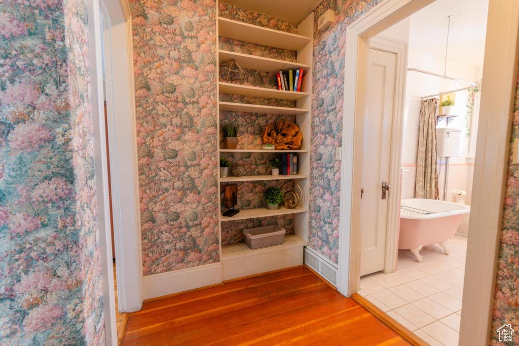 Bathroom with hardwood / wood-style flooring and a washtub