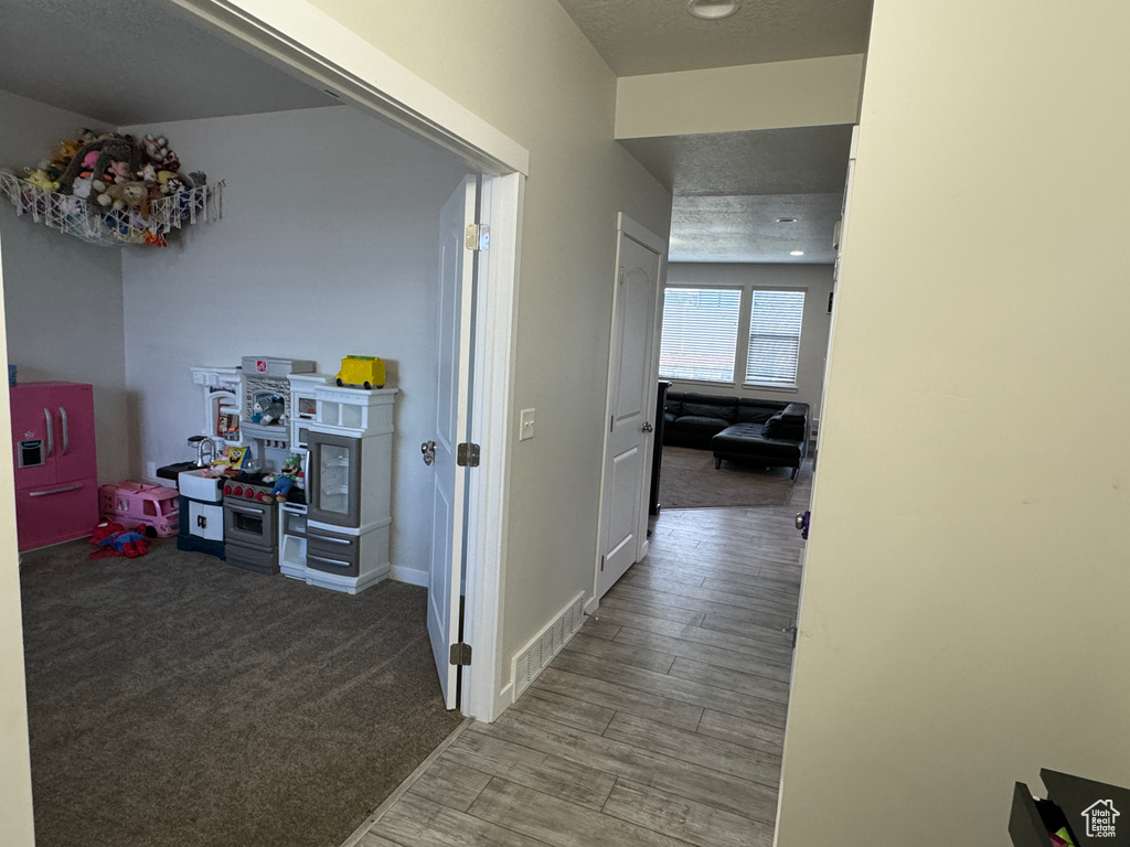 Corridor featuring a textured ceiling and hardwood / wood-style flooring