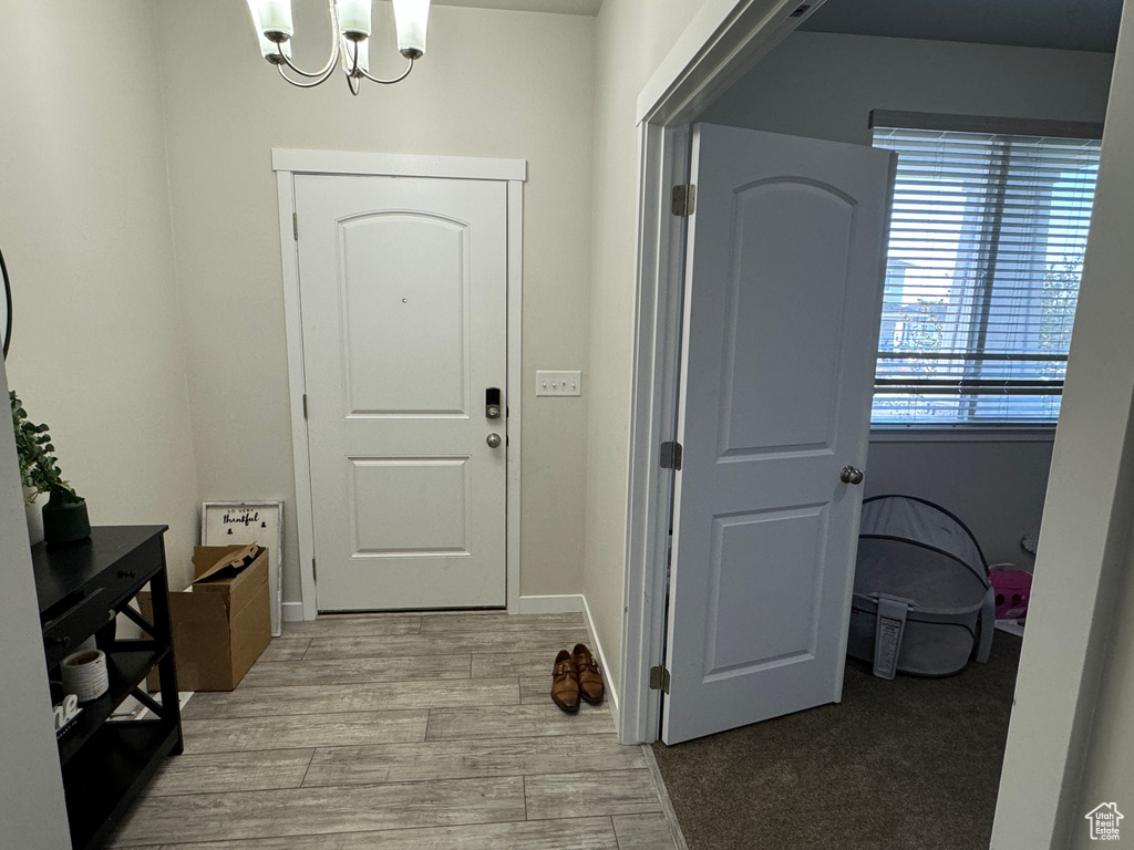 Foyer entrance with a chandelier and light wood-type flooring