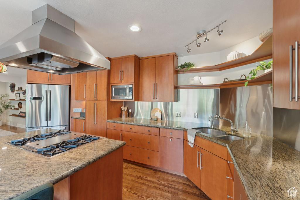 Kitchen featuring island exhaust hood, open shelves, stainless steel appliances, a sink, and light stone countertops