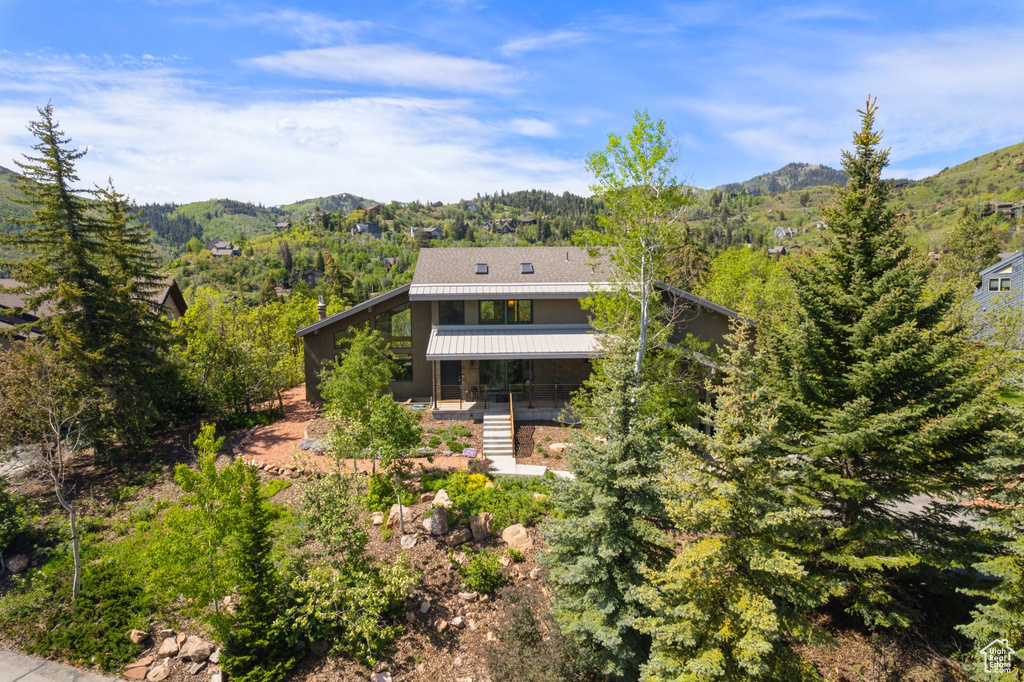 View of front of property with a mountain view and a forest view