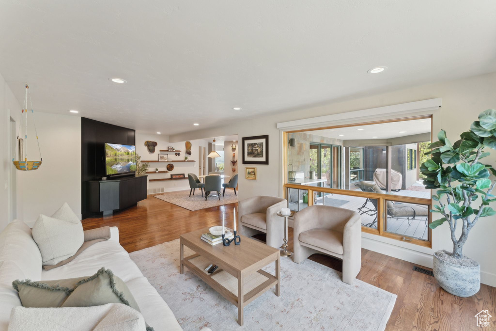 Living area featuring light wood finished floors and recessed lighting