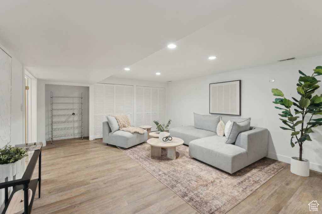 Living room with light wood-style floors, recessed lighting, and baseboards