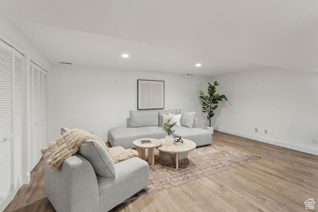 Living room with recessed lighting, wood finished floors, and baseboards