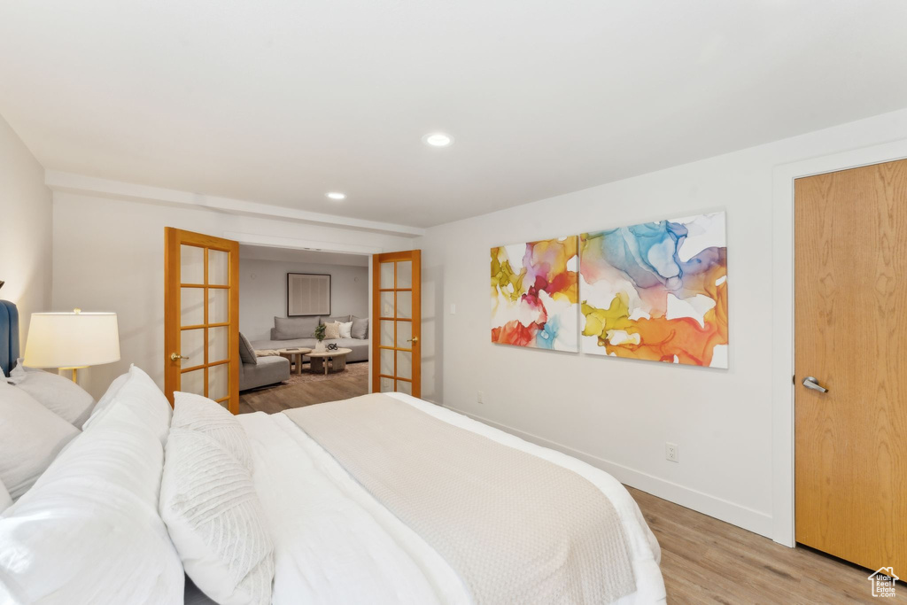 Bedroom featuring french doors, light wood-type flooring, recessed lighting, and baseboards