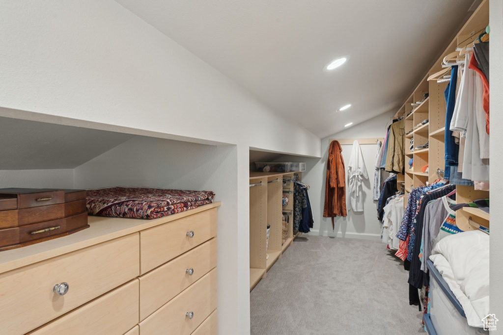 Spacious closet with vaulted ceiling and light colored carpet