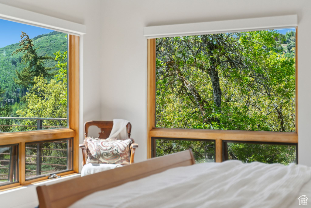 Bedroom featuring a mountain view and multiple windows