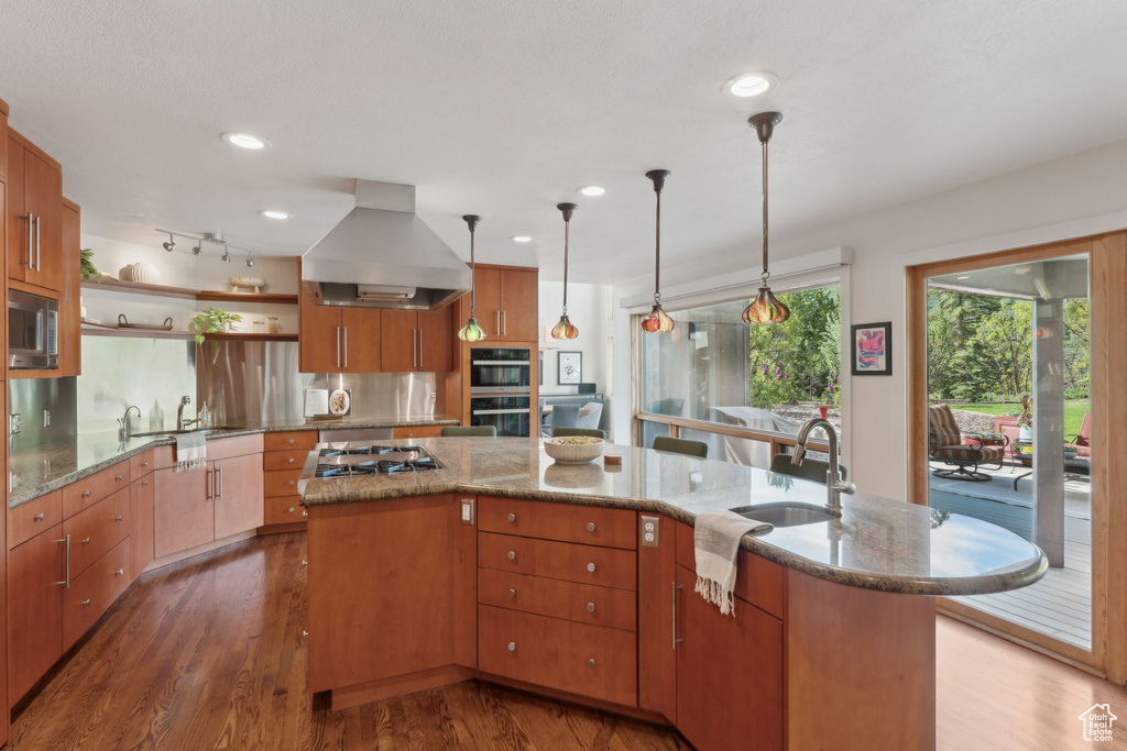 Kitchen with island exhaust hood, stainless steel appliances, a sink, wood finished floors, and open shelves
