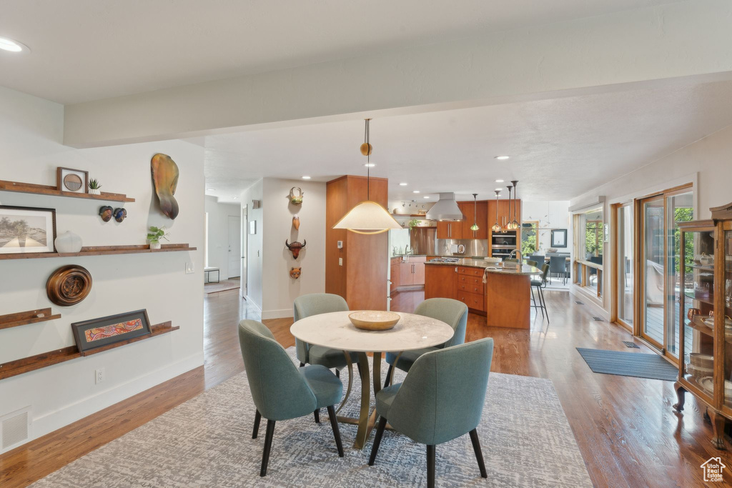 Dining space with light wood-style floors, recessed lighting, and baseboards