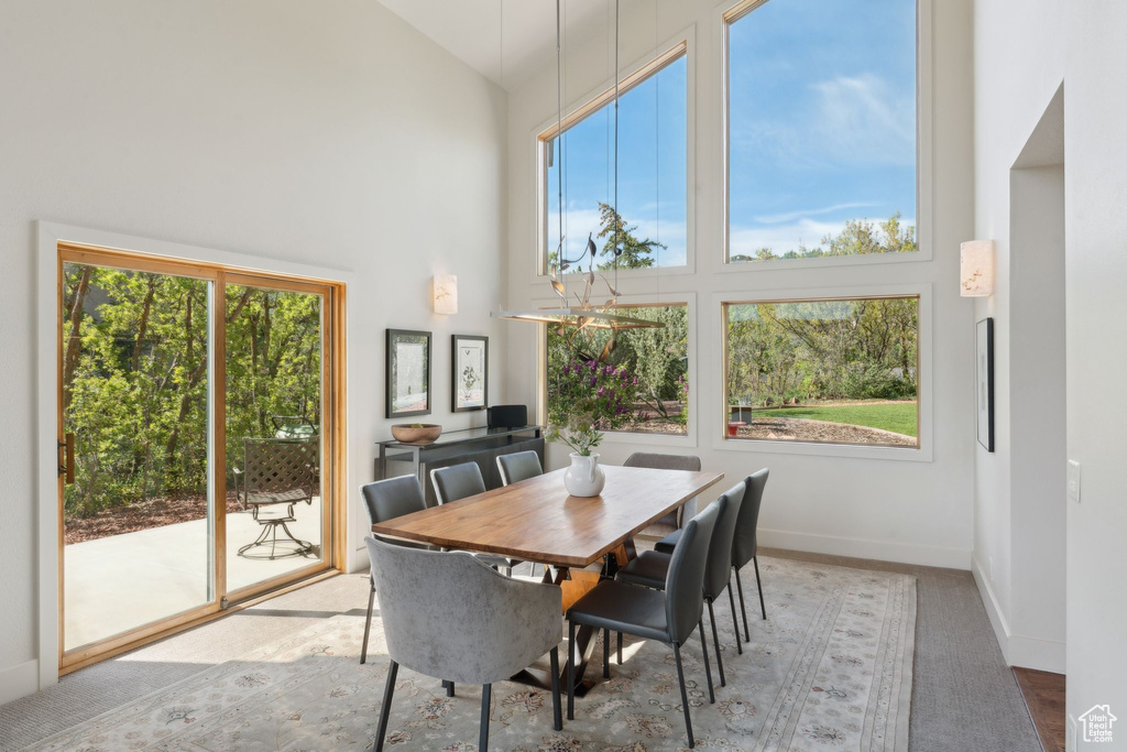 Dining room featuring high vaulted ceiling, healthy amount of natural light, and baseboards