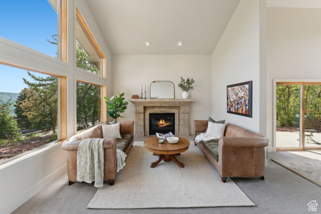 Living room with high vaulted ceiling, carpet, baseboards, a fireplace, and recessed lighting